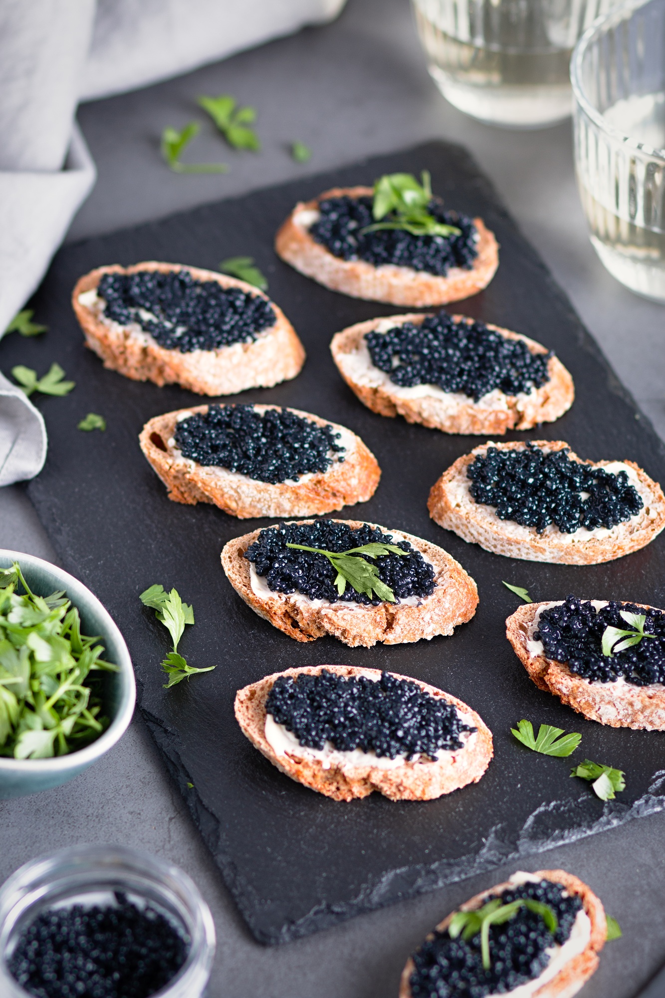 Toasts with black caviar and two glasses of white wine